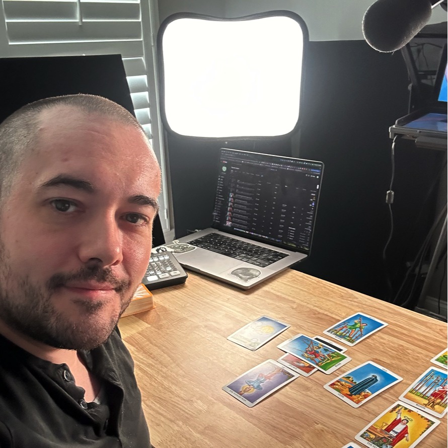 Chris Reck at his desk with tarot cards laid out